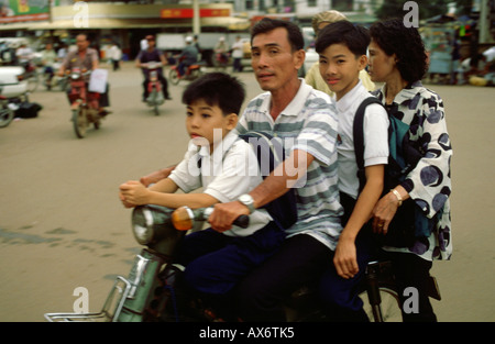 A man with his two children and his wife on their motorbike in Hanoi Vietnam Stock Photo