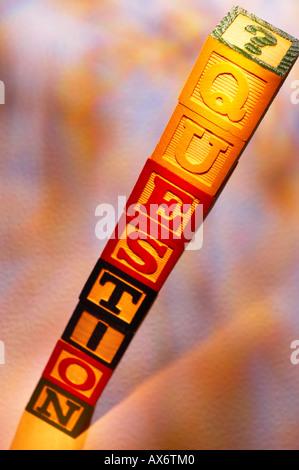 STACK OF WOODEN TOY BUILDING BLOCKS SPELLING THE WORD QUESTION Stock Photo