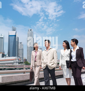 Low angle view of a businessman walking with three businesswomen Stock Photo