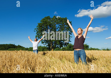 Couple in field with arms outstretched