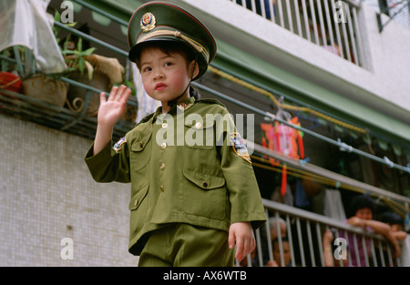 A young Chinese girl dressed as a People s Liberation Army Soldier is carried in a parade at the Cheung Chao Bun Festival Stock Photo