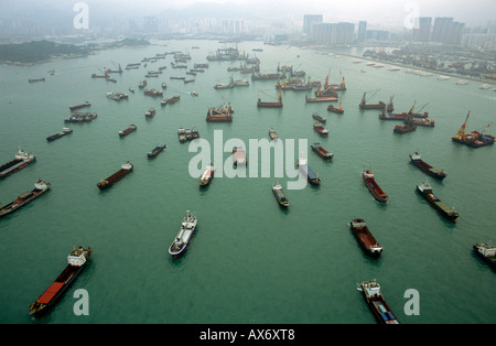 Cargo ships in the bay of Hong Kong await loading and unloading of cargo from their hulls. An aerial view os shipping industry. Stock Photo