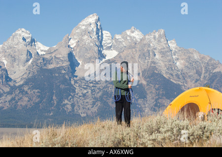 Man coiling rope while camping in Grand Teton National Park CA Stock Photo