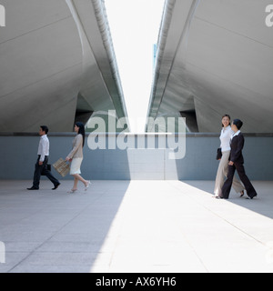 Side profile of three businesswomen and a businessman walking Stock Photo