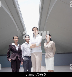 Low angle view of a businessman standing with three businesswomen Stock Photo