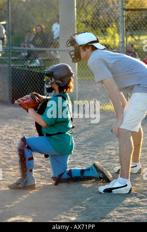 An umpire looks over a catchers shoulder on a baseball field Stock Photo