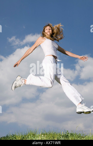 Young woman jumping in mid air Stock Photo