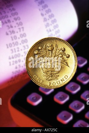 UK Pound coin with calculator and figure list printout Stock Photo