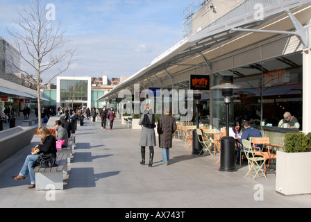 Open public piazza with people enjoying lunch hour amidst shops and restaurants of Brunswick Centre, Bloomsbury, London Stock Photo