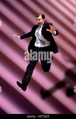 Businessman jumping down stairs Stock Photo