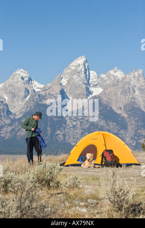 Man coiling rope while camping in Grand Teton National Park CA Stock Photo