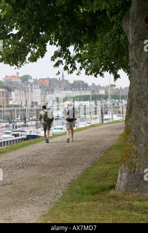 Two ramblers set off on a walk along the promenade towards the mud flats of the Somme Bay St Valery sur Somme Stock Photo