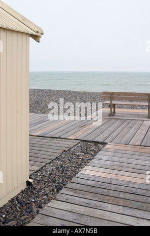 Empty bench on deserted sea front with planked promenade Cayeux sur Mer Somme Stock Photo
