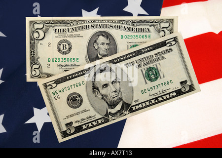 Two styles of American 5 dollar bills set against a Stars and Stripes background. Stock Photo