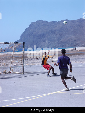 Young men playing football on an asphalt playing field, San Pedro, Sao Vicente, Cape Verde, Africa Stock Photo