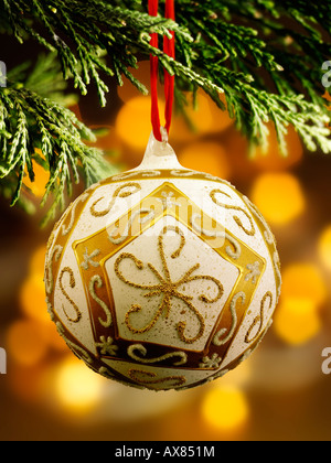 traditional  festive decorated Christmas bauble hanging on a Christmas tree with lights behind Stock Photo