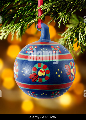 traditional  festive decorated Christmas bauble hanging on a Christmas tree with lights behind Stock Photo