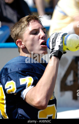 American High School Football player drinking electrolyte drink to replenish electrolytes Stock Photo