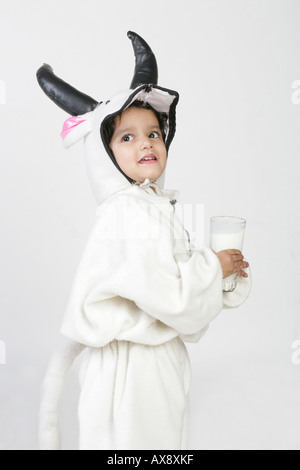 Side profile of a girl in fancy dress drinking milk and smiling Stock Photo