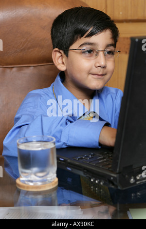 Boy imitating like a businessman and working on laptop Stock Photo