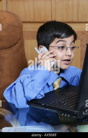 Boy imitating like a businessman and talking on mobile phone Stock Photo