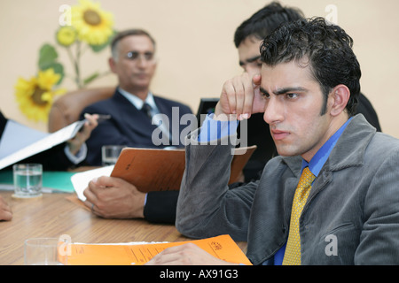 Side profile of a businessman sitting and thinking in a meeting Stock Photo