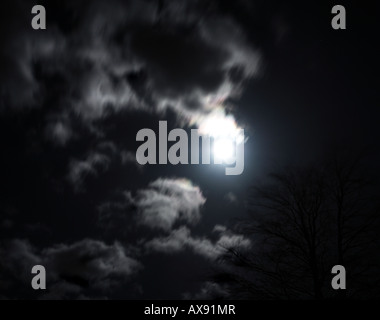 Moon (at the vernal equinox) peeping out from behind beautiful clouds Stock Photo