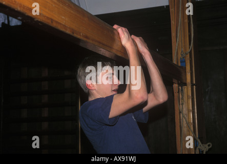 schoolboy exercises in school gym Stock Photo