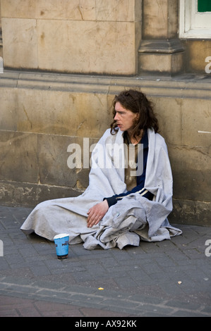 Candid picture of a man begging on a street in Edinburgh, Scotland. Wrapped in a blanket to keep him warm. Stock Photo