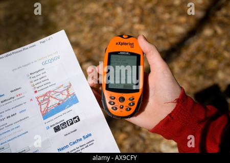 A family uses a hand-held GPS unit to find a Geocache or Geo Cache which is a hiking activity where people search for boxes Stock Photo