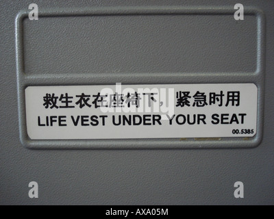 Sign in English and Chines life vest under your seat Stock Photo