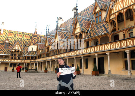 A female tourist reading the guide at Hospices de Beaune, Hotel-Dieu in Beaune, Burgundy, France Stock Photo