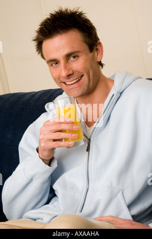 man drinking fresh orange juice Stock Photo