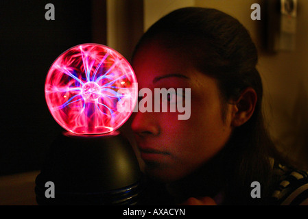 Teen girl stares at plasma lamp Stock Photo
