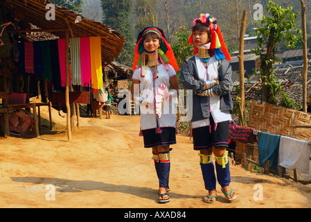 Two longneck women walking in Burmese hilltribe refugee village north Thailand Stock Photo