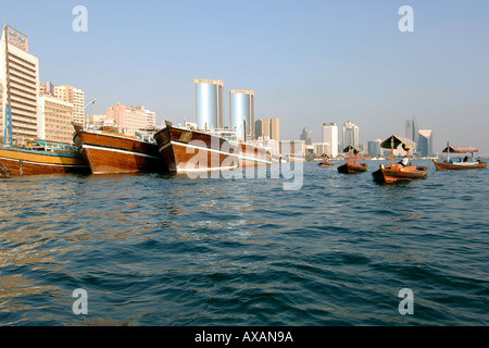 A view along the Dubai creek (Khor Dubai) showing the buildings and wooden ferry boats (called abras). Stock Photo
