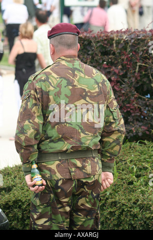 Soldier stands to attention hiding  a beer bottle in his hand Normandy France D-Day Anniversary Stock Photo