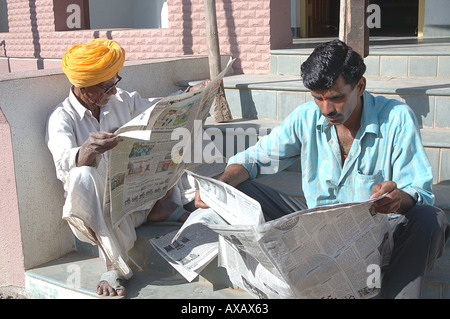 SDM74634 Old man and young man reading news paper Hivre Maharashtra India Stock Photo