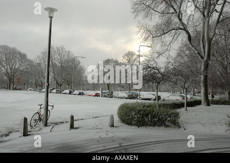 A snow covered road through the park with a bicycle Stock Photo