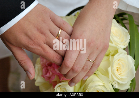 Hands of brides over roses bouquet, France Stock Photo