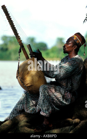 Man playing a harp by the Gambia river, Gambia, Africa Stock Photo