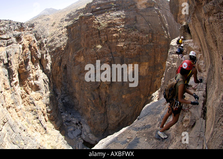 Hikers doing the Via Ferrata hike in Snake Canyon in Jebel Akhdar of the western Hajar mountains in Oman. Stock Photo