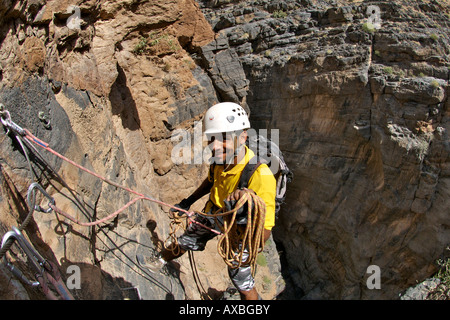 A man doing the Via Ferrata hike in Snake Canyon, part of Wadi Bani Auf in Jebel Akhdar of the western Hajar mountains in Oman. Stock Photo