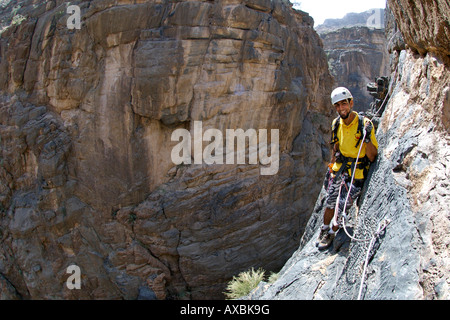 A man doing the Via Ferrata hike in Snake Canyon, part of Wadi Bani Auf in Jebel Akhdar of the western Hajar mountains in Oman. Stock Photo