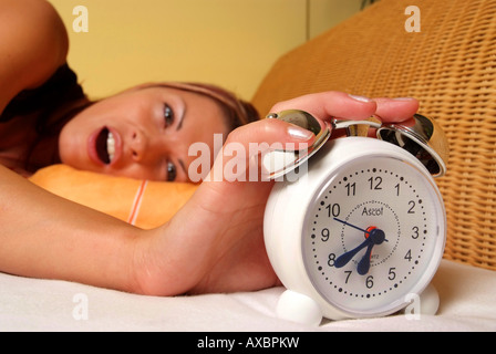 woman wakes up with alarm bell Stock Photo