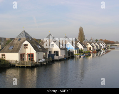 Row of identical Residential houses in modern architecture by the waterside Almere Buiten Netherlands Stock Photo
