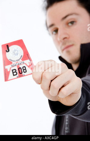 young man holding Austrian vignette 2008 towards the camera, Austria Stock Photo