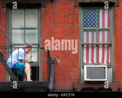 woman smokes a cigarette on balkony, USA, Manhattan, New York Stock Photo