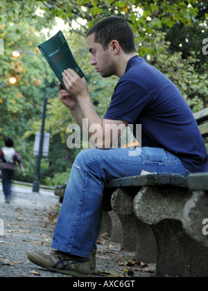young man reading a book in the Central Park, USA, Manhattan, New York Stock Photo