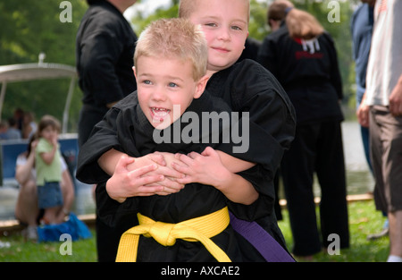 Kids dressed karate outfits play around at outdoor event Stock Photo